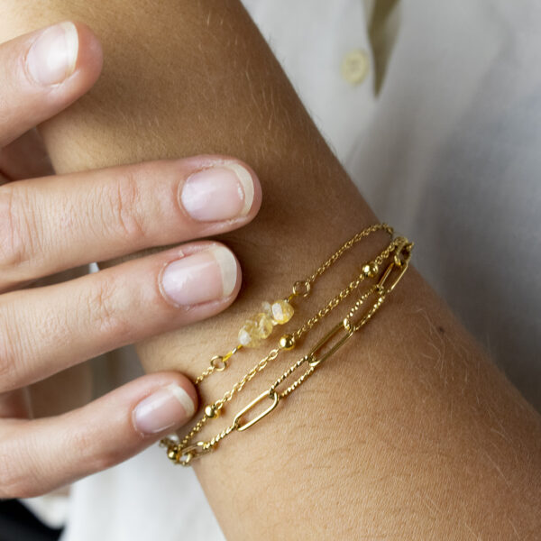 Bracelet en chaines mailles trombones et forçats en acier inoxydable avec fermoir bouée et perles de citrine porté sur un poignet