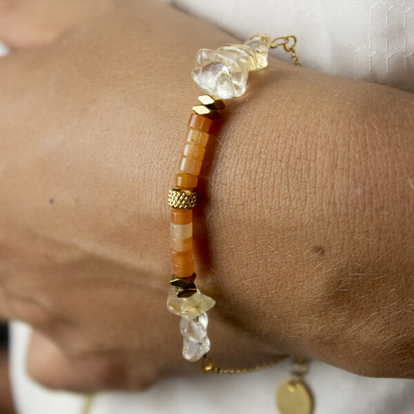 Bracelet en perles de citrine et aventurine orange, porté sur un poignet en gros plan