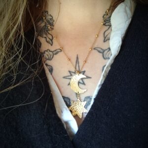 Buste portant un pendentif en forme d'étoile sous une lune en laiton martelé avec chaine boules.