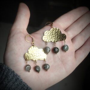 Main portant une paire de boucles d'oreilles en forme de nuage en laiton martelé et gouttes en perles de labradorite